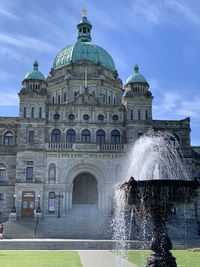 Fountain in front of parliament building against sky in victoria vancouver island 