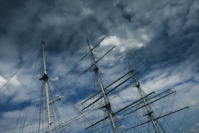 Low angle view of sailboat on sea against cloudy sky