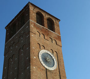 Low angle view of clock tower against blue sky