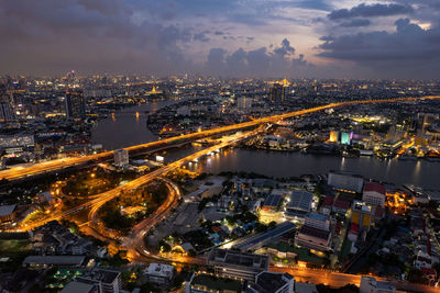 High angle view of illuminated cityscape against sky at night