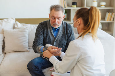 Female doctor examining patient at home