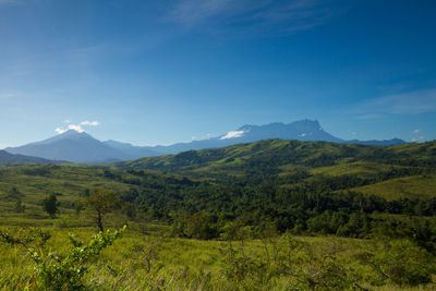 Scenic view of mountains against blue sky