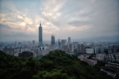 Taipei 101 in city against sky during sunset