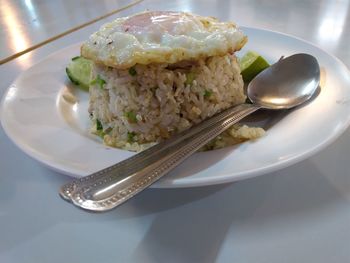 Fried rice and fried egg in plate on table