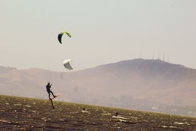 Person paragliding over mountain