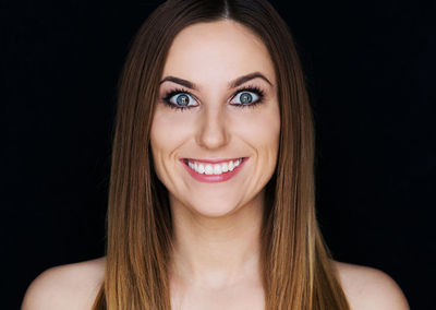 Portrait of cheerful young woman against background