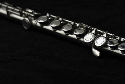 Close-up of guitar on table against black background