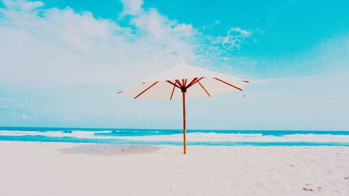 Parasol on beach against sky