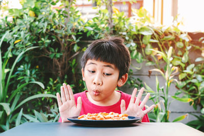 Portrait of boy eating food in restaurant