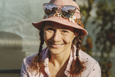 Happy mature woman wearing hat with sunglasses on it