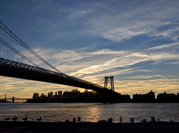 Suspension bridge over river at dusk