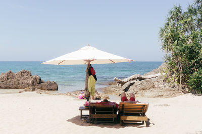 People on beach against clear sky