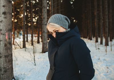 Woman standing in forest during winter