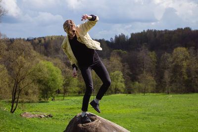 Happy woman standing on rock on grass 