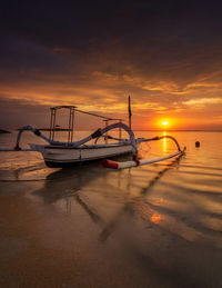 Nautical vessel on sea against sky during sunset