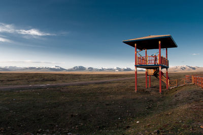 Lifeguard hut on field against sky