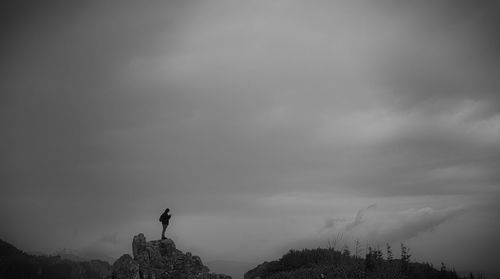 Man standing on mountain against sky