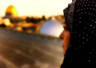 Rear view of people against sky during sunset