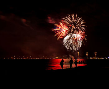 Firework display over sea at night