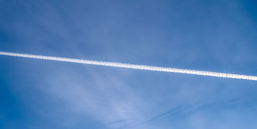 Low angle view of vapor trail against blue sky