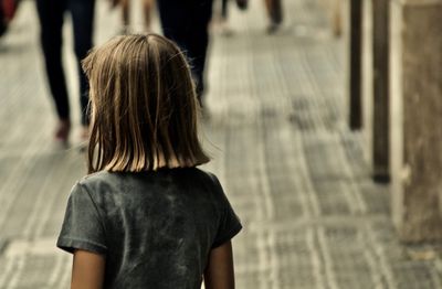 Rear view of girl standing on footpath