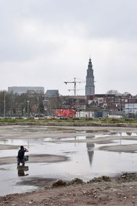 People by building against sky in city