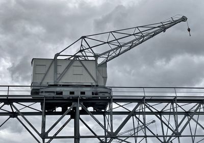 Low angle view of crane against sky