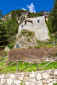 House by tree against sky