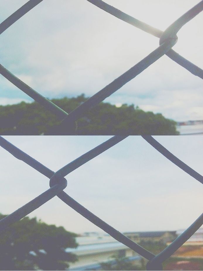 metal, sky, low angle view, fence, protection, safety, chainlink fence, metallic, cloud - sky, security, barbed wire, close-up, cloud, focus on foreground, connection, day, cloudy, no people, outdoors, nature