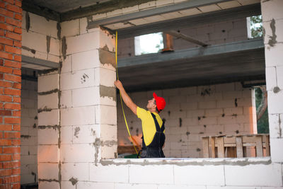 Full length of woman standing against wall