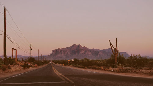 Country road against sky during sunset