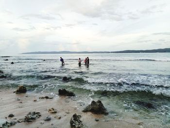 People on beach against sky