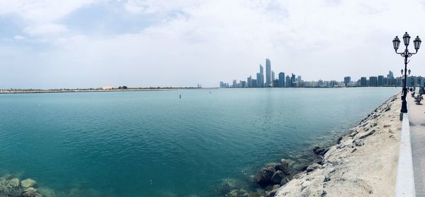 Panoramic view of sea and buildings against sky