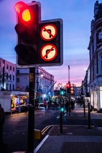 Illuminated road sign on city street at night