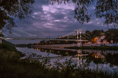 Bridge over river against cloudy sky