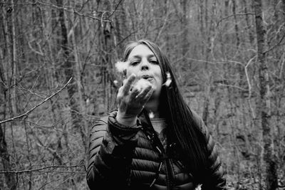 Portrait of young woman standing in forest