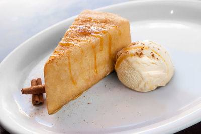 Close-up of cake slice with ice cream served in plate