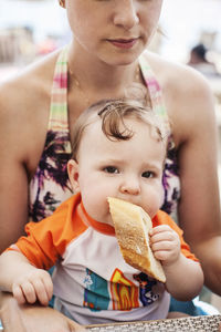 Mother carrying daughter with bread