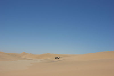 Scenic view of desert against blue sky