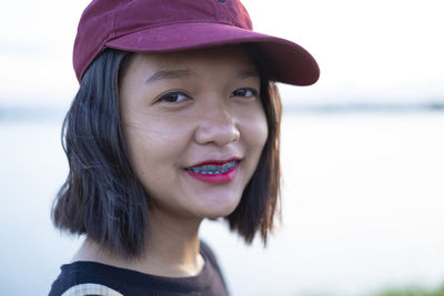 Portrait of smiling girl wearing cap standing outdoors