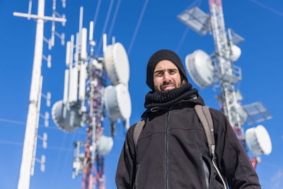 Low angle portrait of man standing against sky