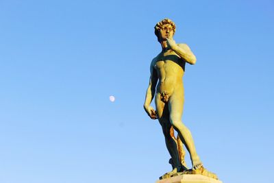 Low angle view of statue against blue sky