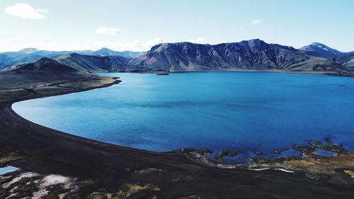 Scenic view of sea and mountains against sky