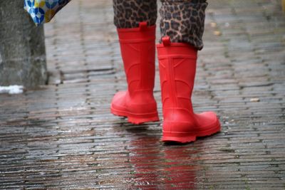 Low section of woman walkinng in rain with rubber boats