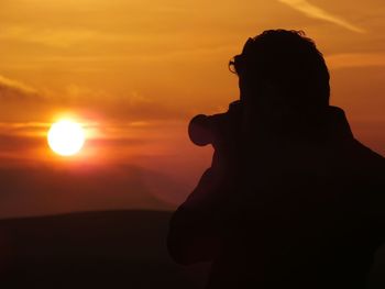 Silhouette of man photographing through camera