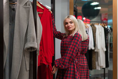 Portrait of smiling woman standing in clothing store