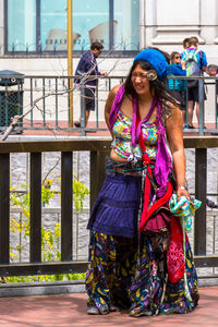 Portrait of happy woman standing against wall