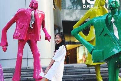 Woman with umbrella standing against the wall