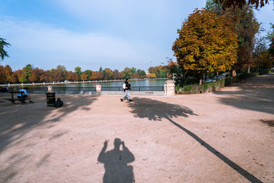 Shadow of man on footpath against sky