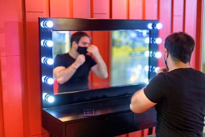 Rear view of man photographing illuminated